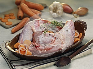 Guinea-fowl legs with carrots before cooking
