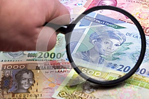 Guinean money in a magnifying glass