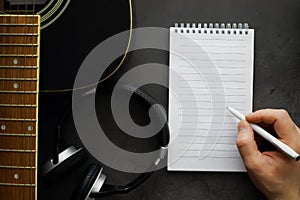 Guitar and accessories on a stone background. Desk musician, headphones, microphone