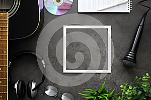 Guitar and accessories on a stone background. Desk musician, headphones, microphone