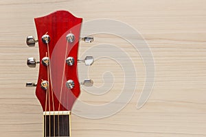 Guitar acoustic red, the neck lies on the wooden wall light background classical Spanish, rectangular format music