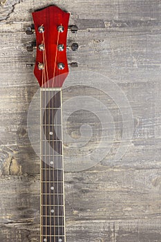 Guitar acoustic red, neck lying on a vintage background of wood on the background of old grunge boards. Place for text
