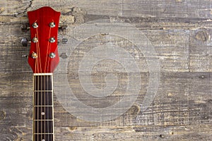 Guitar acoustic red, neck lying on a vintage background of wood on the background of old grunge boards. Place for text