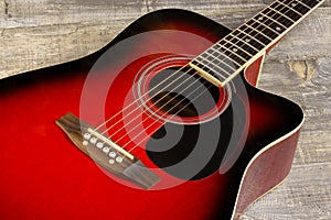 Guitar acoustic red, neck lying on a vintage background of wood on the background of old grunge boards. View