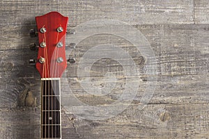 Guitar acoustic red, neck lying on a vintage background of wood on the background of old grunge boards. Place for text