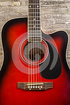 Guitar acoustic red, neck lying on a vintage background of wood on the background of old grunge boards. View