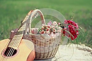 Guitar, basket and bouquet of flowers. Vintage tender background