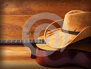 Guitar and cowboy hat on wood background