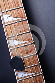 Guitar frets with strings and mediator on dark