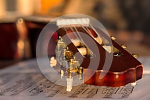 Guitar headstock on old music notes, close up