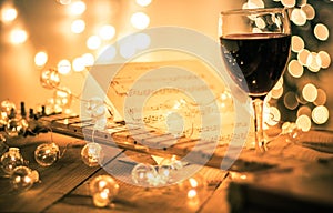 Guitar with instrumental sheet music and soft lights and red wine for Christmas holiday, split tone