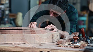 Guitar luthier carefully places the back of guitar in mold