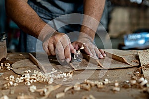 Guitar luthier using small planer to fine-tune bracing of acoustic guitar