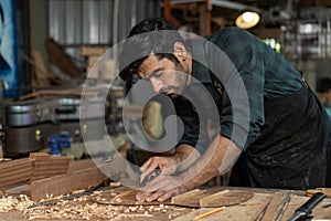 Guitar luthier using small planer to fine-tune bracing of acoustic guitar