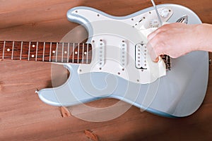 Guitar master polishing electric guitar with cloth photo