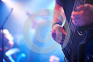 Guitar, music festival and man with a band on stage for a show, performance or night event. Party, rock and hands of a