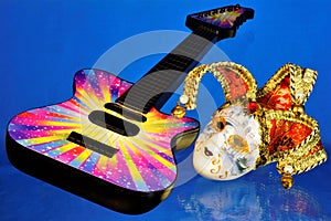 Guitar musical instrument, mask cheerful carnival performance. The mask is a symbol of theatrical transformation, change and