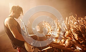 Guitar, musician and concert crowd at stage with man in performance of rock or metal music. Festival, event and audience