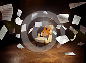 Guitar on an old chair with flying music sheets