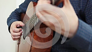 Guitar player man on a light romantic background with lights. Fingerstyle technique