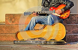 Guitar player with open guitar case