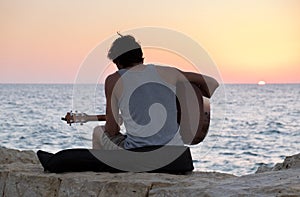 The guitar player on Tel-Aviv beach at sunset