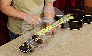 Guitar repair and service - Worker sharpen special tool bridge servo nut black guitar