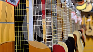 Guitar Shop. Lots of New Multicolored Acoustic Guitars are Hung in Music Store