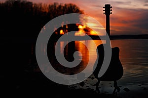 Guitar by the lake at sunset time