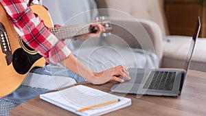 Guitar and singer concept, Young asian woman playing acoustic guitar while learning music on laptop