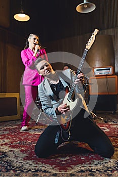 Guitar solist playing solo on his knees and a singer singing during the rehearsal photo