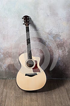 The guitar stands near the wall in the style of grunge, music, musician, hobby, lifestyle, hobby