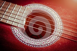 Guitar strings. Flamenco guitar. Music style background. Photo of an acoustic guitar in dark orange. Closeup photography of an