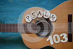 Guitar on teal wood with the word: PSALM 103