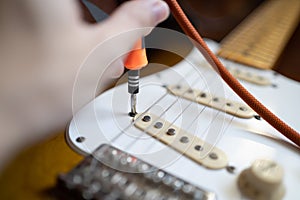 Guitar technician setting the height of guitar pickup