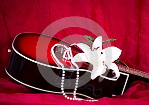 Guitar with white lily on red backgr