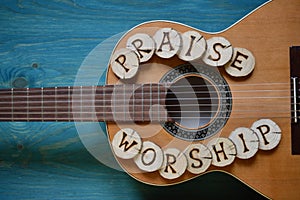 Guitar on wood with words: PRAISE and WORSHIP