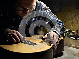 Guitars Luthiers installs a saddle. photo