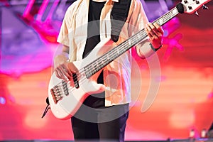 Guitarist bass showing on concert stage. Enterment and music concept