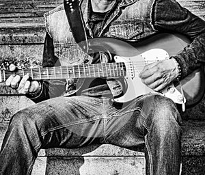 Guitarist with a colorful electric guitar in b&w