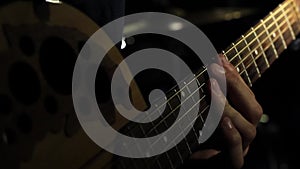 Guitarist hand on guitar neck with strings playing chords
