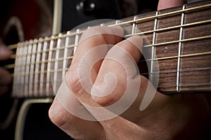 Guitarist hand playing acoustic guitar