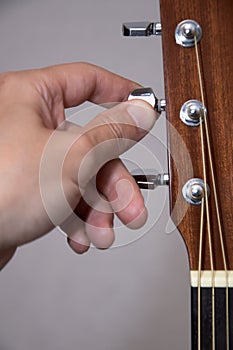 Guitarist hand tuning acoustic guitar