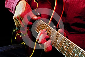 Guitarist hands and guitar close up.