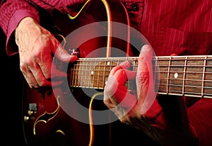 Guitarist hands and guitar close up.