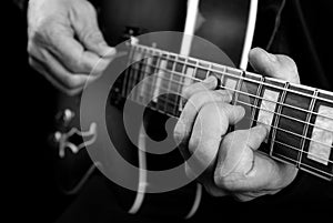 Guitarist hands and guitar close up. playing electric guitar. play the guitar. black and white.