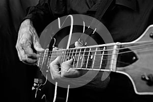 Guitarist hands and guitar close up. playing electric guitar. play the guitar. black and white.