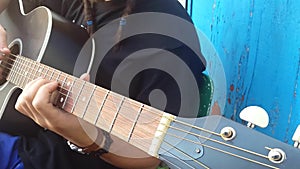 Guitarist hands playing song on acoustic guitar