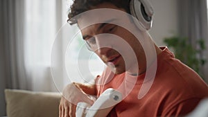 Guitarist hands rehearsing song at home closeup. Man headphones playing guitar