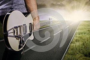 Guitarist and his guitar on the road